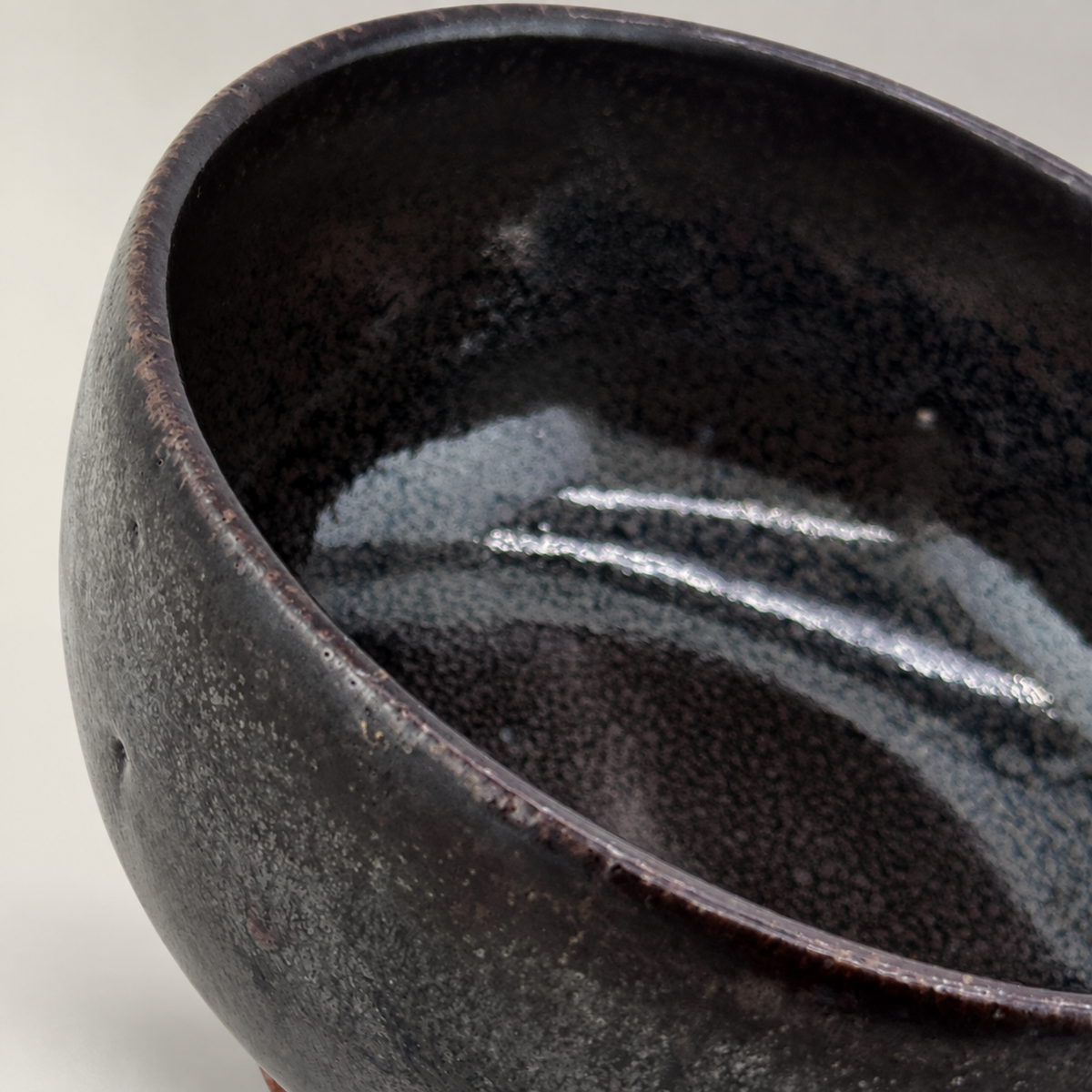 Kuro-yū Chawan – Detail der Innenglasur auf neutralem Hintergrund